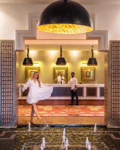 a woman in a white dress dancing in a fountain at Berbère Palace in Ouarzazate