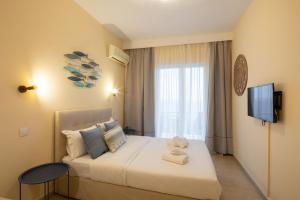 アギオス・イオアニス・ペリステリオンにあるAurora Beach Hotelのベッドとテレビが備わるホテルルームです。