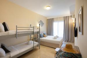 アギオス・イオアニス・ペリステリオンにあるAurora Beach Hotelの二段ベッド2台と窓が備わる客室です。