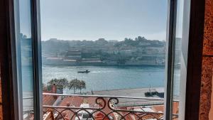 ein Fenster mit Blick auf das Wasser aus einem Gebäude in der Unterkunft Authentic Porto House in Porto