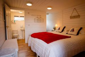 a bedroom with a white bed with a red blanket at Seagrove Beach Cabin in Seaview