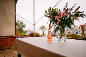 einen Tisch mit einer Blumenvase auf dem Balkon in der Unterkunft Seagrove Beach Cabin in Seaview