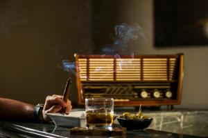 a person smoking a cigar and a glass of smoke at Berbère Palace in Ouarzazate