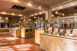 a restaurant with a large kitchen with tables and counters at Berbère Palace in Ouarzazate