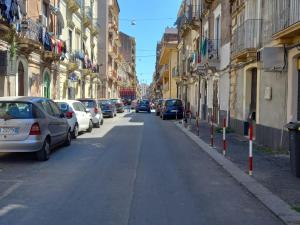 een straat met auto's aan de kant van de weg bij Single Room in Historical City Centre with Private Bathroom in Catania