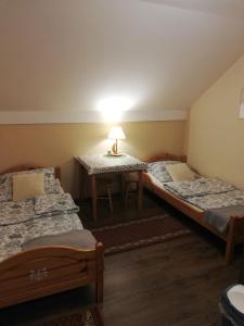 a room with two beds and a table with a lamp at Pokoje Gościnne u Joli in Szczyrk