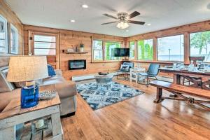 a living room with wooden walls and a ceiling fan at Houghton Lake Cottage with New Private Deck! in Houghton Lake