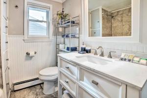 a white bathroom with a sink and a toilet at Houghton Lake Cottage with New Private Deck! in Houghton Lake +23 photos