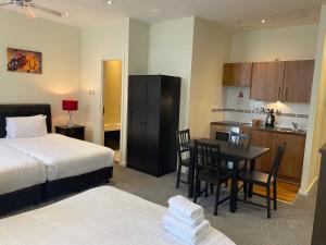ロンドンにあるグランド プラザ サービス アパートメントのベッドルーム1室(ベッド1台、テーブル付)、キッチン
