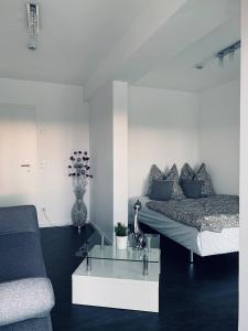 ein Wohnzimmer mit einem Bett und einem Couchtisch aus Glas in der Unterkunft Apartment mit Penthouse Charakter in Dresden in Dresden