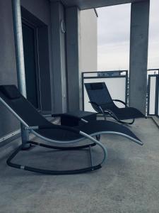 two chairs sitting on the balcony of a building at Apartment mit Penthouse Charakter in Dresden in Dresden