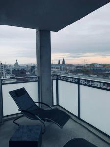a chair on a balcony with a view of a city at Apartment mit Penthouse Charakter in Dresden in Dresden
