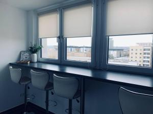 Un bar con cuatro sillas en una habitación con ventanas. en Apartment mit Penthouse Charakter in Dresden, en Dresden 19 fotos más