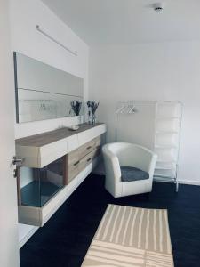 ein Badezimmer mit einem Waschbecken, einem Stuhl und einem Spiegel in der Unterkunft Apartment mit Penthouse Charakter in Dresden in Dresden