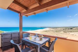 un tavolo e sedie su un balcone con vista sulla spiaggia di SARDEGNA a Torre Dei Corsari