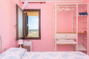 una camera da letto con pareti rosa, letti a castello e specchio di SARDEGNA a Torre Dei Corsari