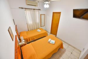 Kleines Zimmer mit 2 Betten und einem TV in der Unterkunft Hotel Simón in Trenque Lauquen