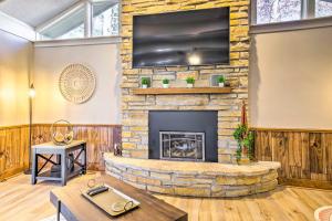 sala de estar con chimenea de piedra y TV de pantalla plana en Beautiful Home with Hot Tub on Lake Wissota, en Chippewa Falls