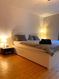 a bedroom with a large bed with two lamps at Ferienwohnung mit Sauna am Wald - Eifel in Kommern
