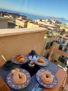 three plates of donuts on a table on a balcony at Casa Flegrea Bagnoli in Naples