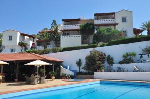 een villa met een zwembad voor een gebouw bij Castri Village Hotel in Palekastron