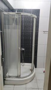 La salle de bains est pourvue d'une douche avec une porte en verre. dans l'établissement 2+1 Aileye Uygun Haftalik ve Aylik, à Istanbul