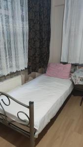 - un petit lit dans une chambre avec des rideaux dans l'établissement 2+1 Aileye Uygun Haftalik ve Aylik, à Istanbul