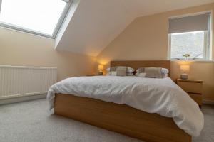 a bedroom with a large bed with a skylight at Fishertown House in Nairn