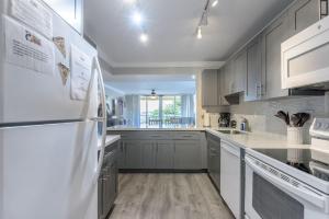 a kitchen with white appliances and a white refrigerator at 2x2 Fully Updated Old Town Waterfront Corner Condo in Key West