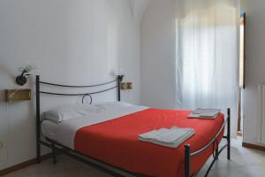 a bedroom with a red and white bed with towels on it at Ostello-Albergo dagli Elfi in Barrea