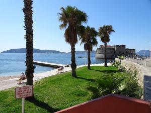 un cartel en una playa con palmeras y agua en TOULON - Côte d'Azur - Magnifique maison avec piscine privée, en Toulon