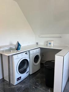 a laundry room with a washing machine and a counter at Rymlig och modern lägenhet i villa. Perfekt för familjer. Med parkering. in Malmö