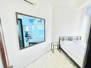 een slaapkamer met een spiegel, een bed en een tafel bij Suite Casa del Sole 22 - Fronte mare in Sanremo