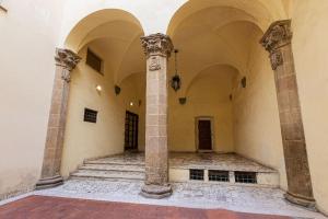 una habitación vacía con columnas y escaleras en un edificio en Ponte Vecchio - Appartamenti Borgo San Jacopo, en Florencia