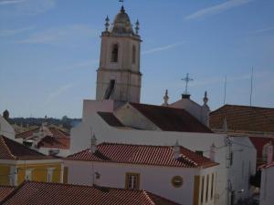 budynek z wieżą zegarową z czerwonymi dachami w obiekcie Casa Azul em Alcantarilha - Algarve w mieście Alcantarilha