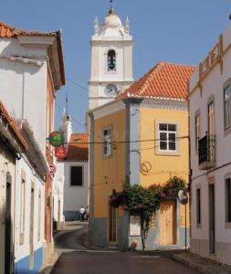 een stadsstraat met een klokkentoren in de verte bij Casa Azul em Alcantarilha - Algarve in Alcantarilha