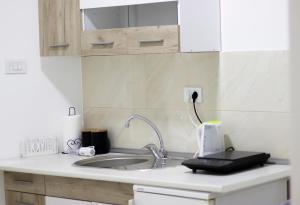 a kitchen counter with a sink and a mirror at Town Space Apartment Niš in Niš +18 photos