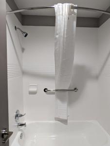 a white bathroom with a sink and a shower curtain at OKC Hotel in Oklahoma City