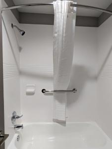 a white bathroom with a sink and a towel rack at OKC Hotel in Oklahoma City