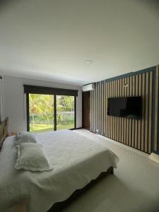 a bedroom with a large bed and a flat screen tv at Cabaña en santafe de Antioquia in Santa Fe de Antioquia