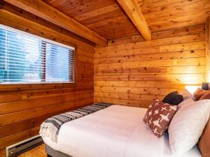 1 dormitorio con 1 cama en una cabaña de madera en Creekside Cottage, en Glacier