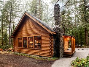 Cabaña de madera en el bosque con ventana grande en Creekside Cottage, en Glacier