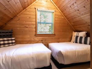 a bedroom with two beds in a log cabin at Heliotrope Haus in Glacier
