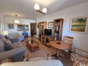 un salon avec un canapé et une télévision dans l'établissement Apartamento vacacional Marita, à Nueva de Llanes