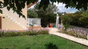 a garden with purple flowers and a gate at Kampas studios in Agios Georgios