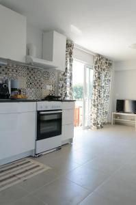 cocina con electrodomésticos blancos y ventana grande en Beautiful seaside studio with amazing view en Atenas