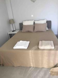 ein großes Bett mit zwei Handtüchern darüber in der Unterkunft Beautiful seaside studio with amazing view in Athen