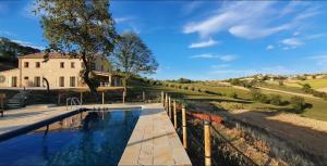 a pool of water in front of a house and a building at casale dei cinque colli APPARTAMENTO in Ostra +15 photos