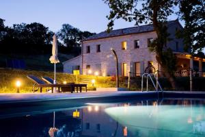 a house and a swimming pool in front of a building at casale dei cinque colli APPARTAMENTO in Ostra