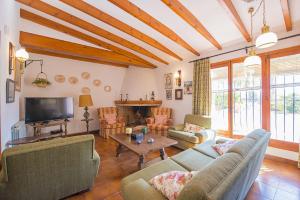 a living room with couches and a tv at Villa Mas Blanc - PlusHolidays in Benissa